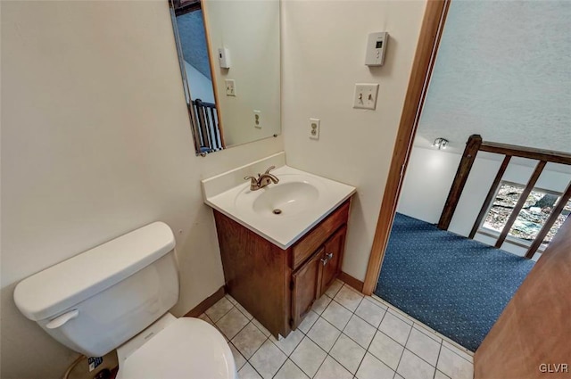 half bath featuring tile patterned floors, toilet, and vanity