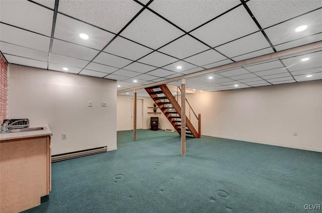 finished basement featuring a sink, a baseboard heating unit, recessed lighting, stairway, and carpet floors