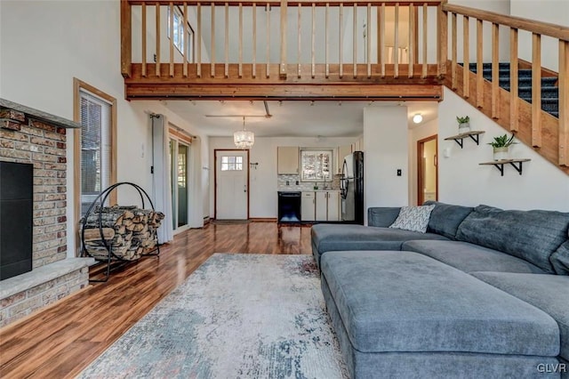 living room featuring baseboards, stairs, a high ceiling, and wood finished floors