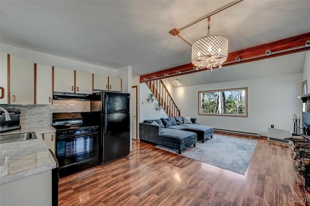 kitchen with black appliances, a sink, exhaust hood, light countertops, and a baseboard radiator