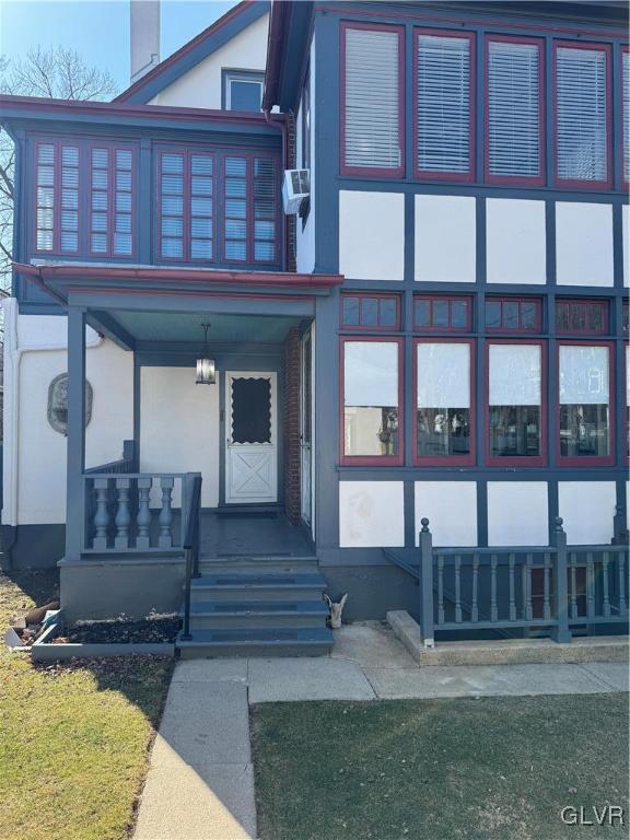 entrance to property with a porch and stucco siding