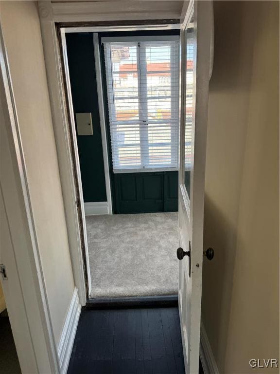 interior space with baseboards and dark colored carpet