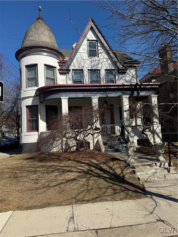 victorian-style house with covered porch and stucco siding