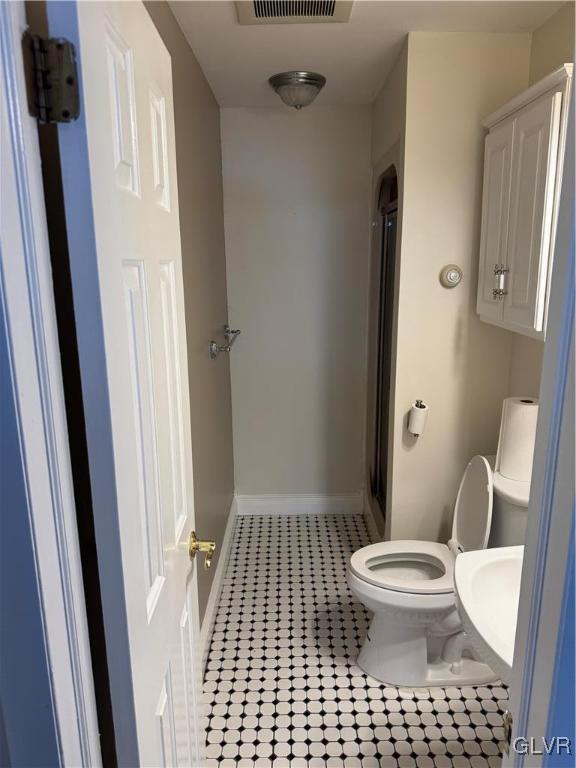 bathroom featuring visible vents, baseboards, tile patterned flooring, a shower stall, and toilet