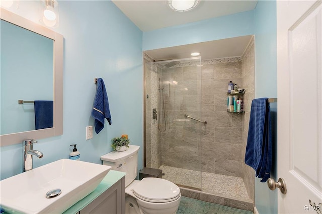 bathroom with toilet, vanity, and a tile shower