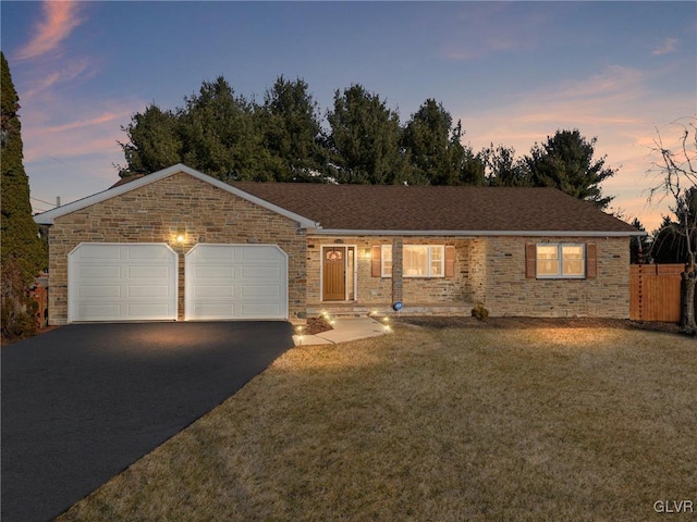 single story home featuring aphalt driveway, fence, a lawn, and a garage