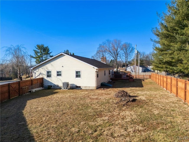 view of home's exterior with a yard, central air condition unit, a fenced backyard, and a chimney