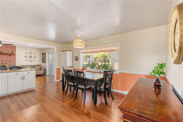 dining space with light wood finished floors and baseboards