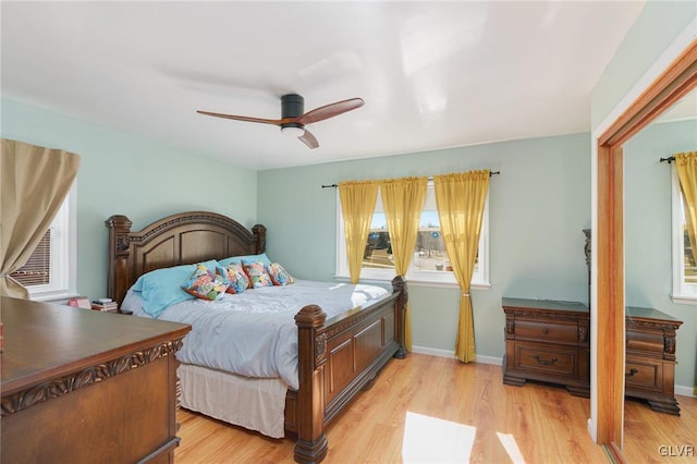 bedroom with ceiling fan, baseboards, and light wood-style flooring