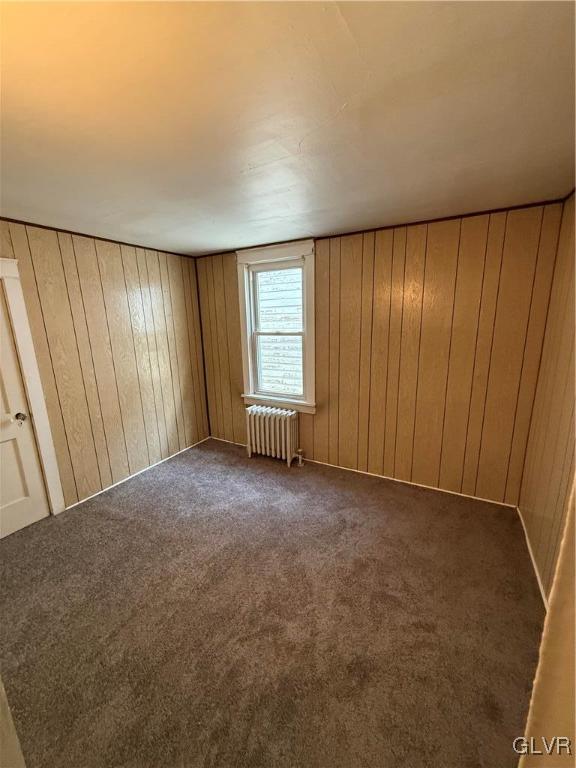 interior space featuring wooden walls and radiator