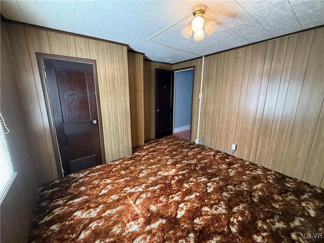 carpeted empty room with wooden walls