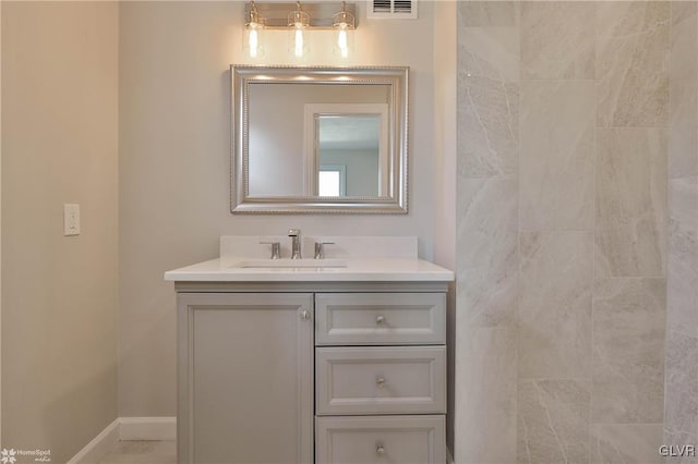 bathroom with vanity, visible vents, and baseboards