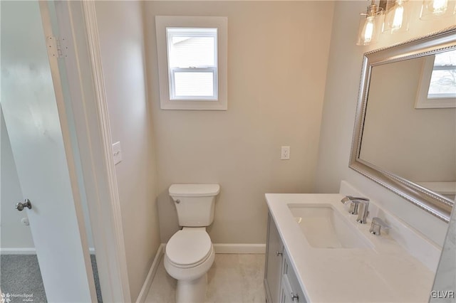 bathroom featuring baseboards, toilet, and vanity