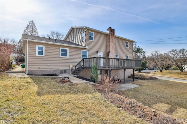 rear view of house featuring a wooden deck, a lawn, a chimney, and stairway