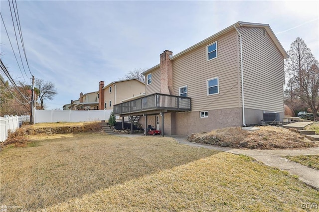 rear view of property featuring a deck, central AC, fence, a yard, and a chimney