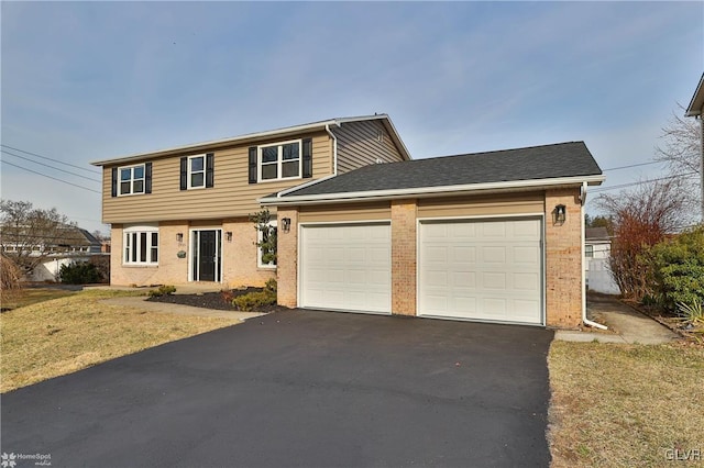 colonial home with driveway, brick siding, and an attached garage