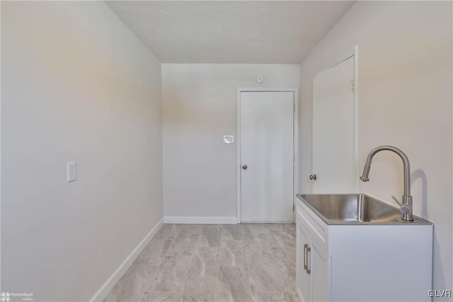 laundry area with baseboards and a sink