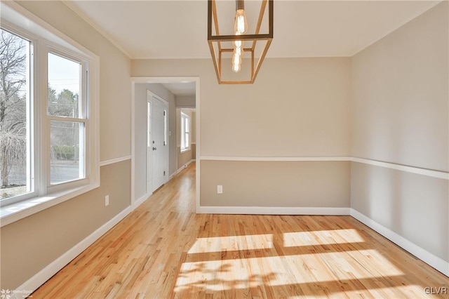 unfurnished room featuring baseboards and wood finished floors