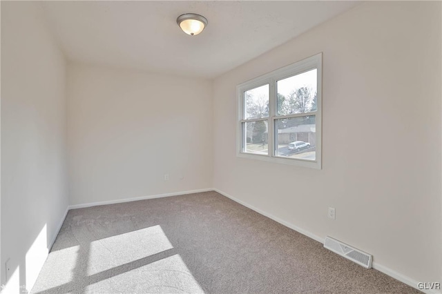 carpeted empty room featuring visible vents and baseboards