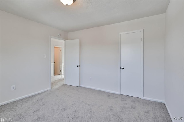 unfurnished bedroom featuring baseboards and carpet