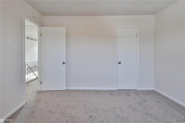 carpeted empty room with visible vents and baseboards