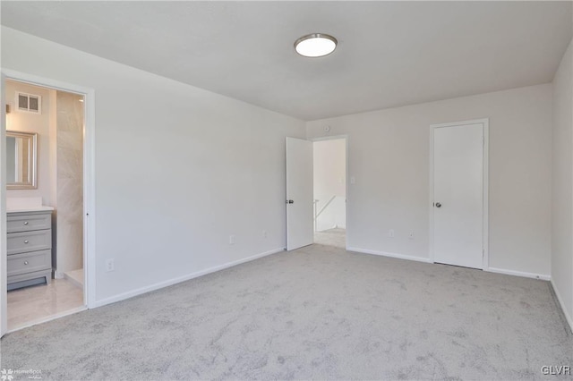 unfurnished bedroom featuring baseboards, visible vents, carpet floors, and connected bathroom