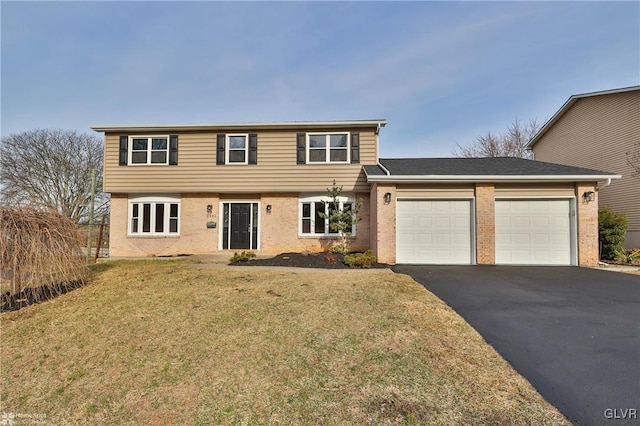 colonial house with brick siding, an attached garage, aphalt driveway, and a front lawn