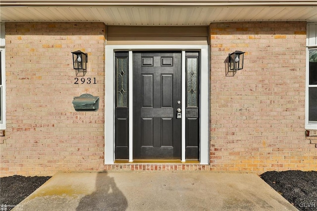 doorway to property featuring brick siding