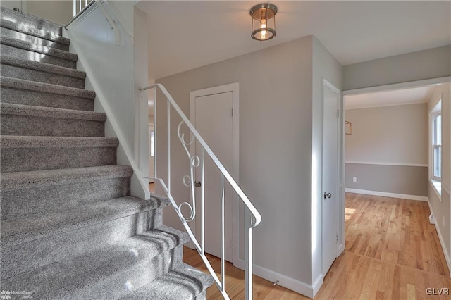 stairway featuring baseboards and wood finished floors