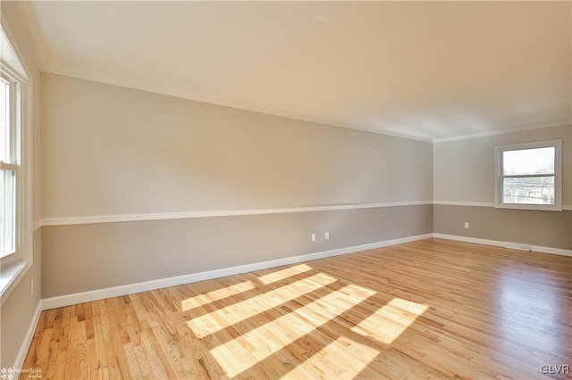 unfurnished room featuring visible vents, baseboards, light wood-style flooring, and ornamental molding