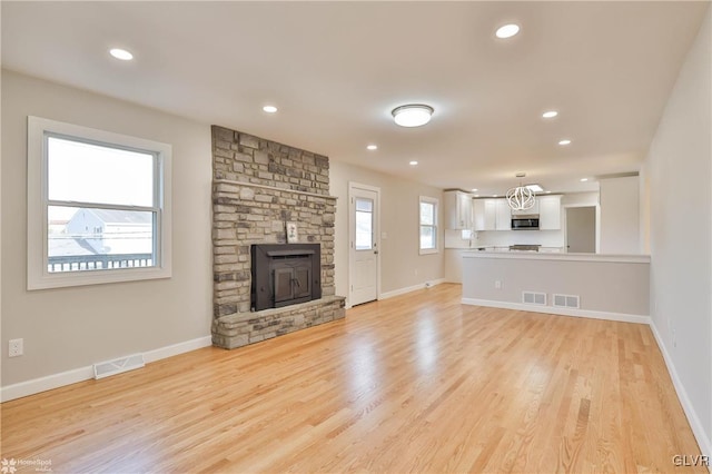 unfurnished living room with recessed lighting, visible vents, light wood-style flooring, and baseboards