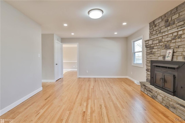 unfurnished living room featuring a fireplace, light wood-style floors, and baseboards