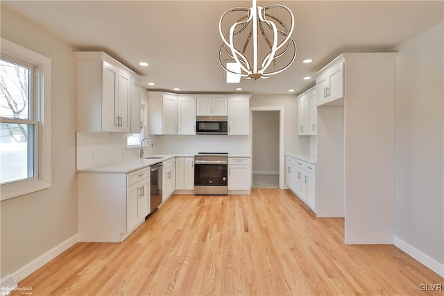 kitchen with light wood finished floors, plenty of natural light, stainless steel appliances, and light countertops