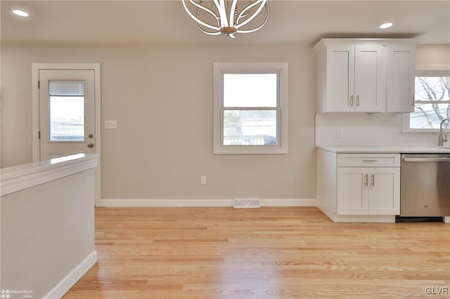 kitchen featuring visible vents, baseboards, an inviting chandelier, white cabinetry, and stainless steel dishwasher