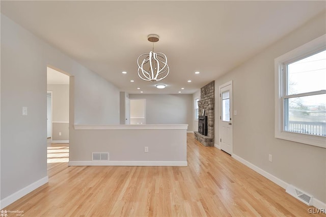 interior space with a chandelier, visible vents, light wood-type flooring, and baseboards