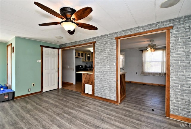 unfurnished living room featuring visible vents, wood finished floors, baseboards, and ceiling fan