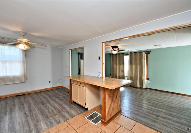 kitchen with visible vents, baseboards, ceiling fan, and wood finished floors