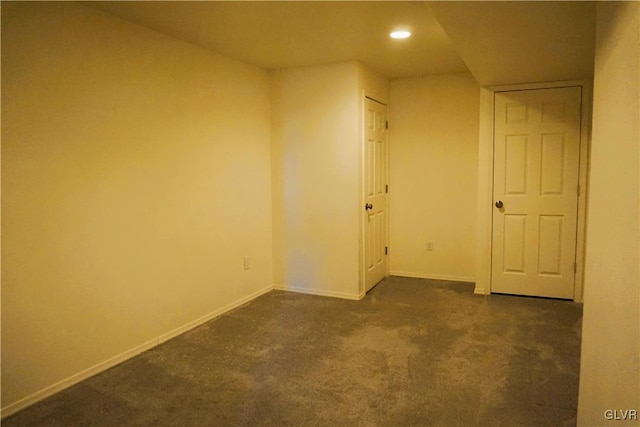 spare room with recessed lighting, baseboards, and dark carpet