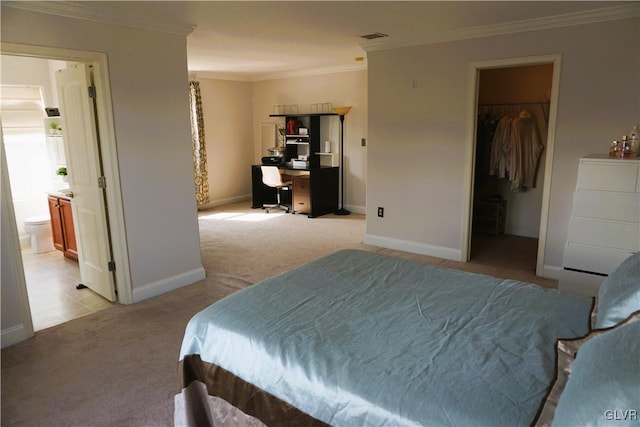 bedroom featuring visible vents, light carpet, a walk in closet, crown molding, and baseboards