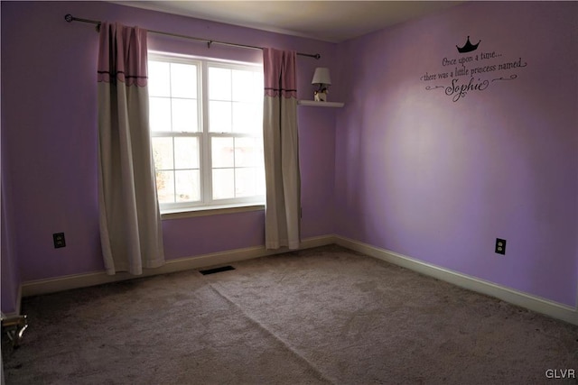 spare room featuring carpet, visible vents, a wealth of natural light, and baseboards