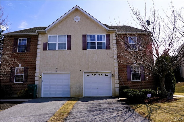 view of front of home with aphalt driveway, an attached garage, and stucco siding