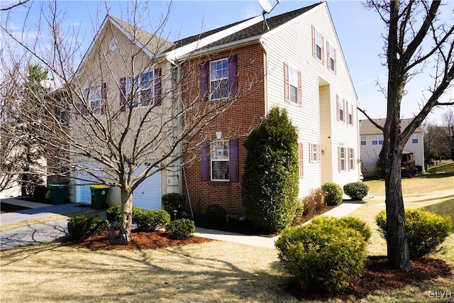 view of home's exterior with brick siding, a lawn, and an attached garage