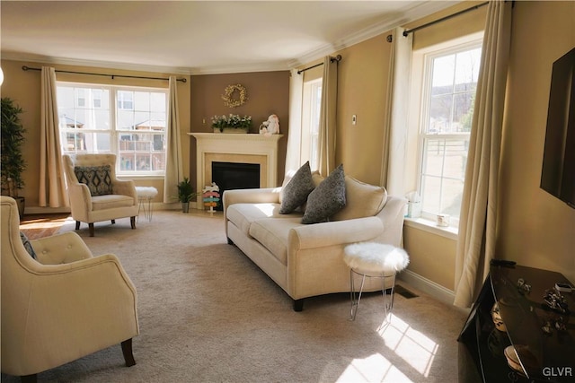 living area with baseboards, carpet floors, a fireplace, and crown molding