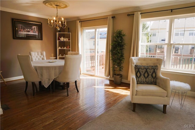 dining room featuring baseboards, a notable chandelier, wood finished floors, and crown molding