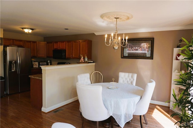 dining space with visible vents, ornamental molding, an inviting chandelier, baseboards, and dark wood-style flooring