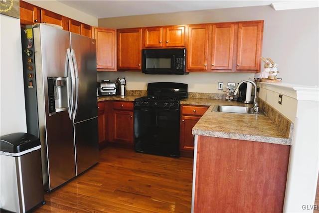 kitchen featuring a sink, brown cabinets, black appliances, and dark wood finished floors