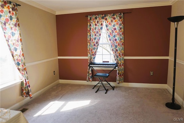 spare room featuring baseboards, crown molding, and carpet