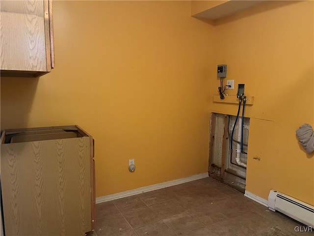 clothes washing area featuring cabinet space, baseboards, baseboard heating, and hookup for a washing machine