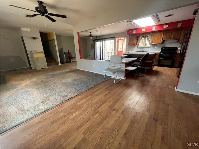 kitchen with wood finished floors, ceiling fan, extractor fan, light countertops, and range with electric stovetop