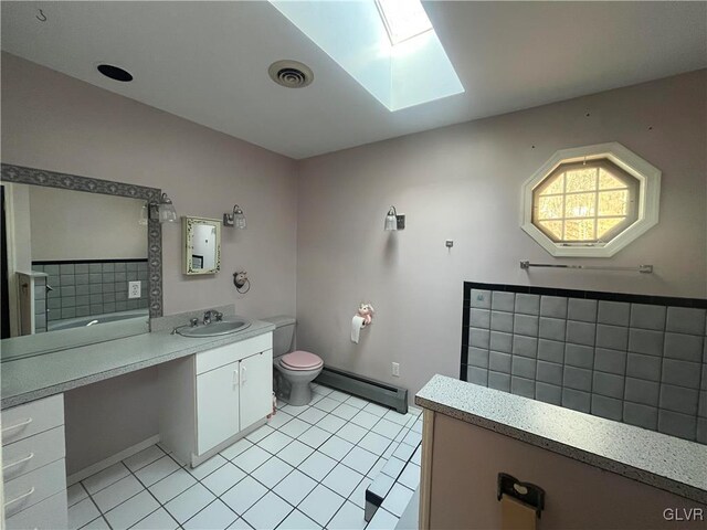 bathroom with visible vents, a baseboard heating unit, toilet, a skylight, and vanity